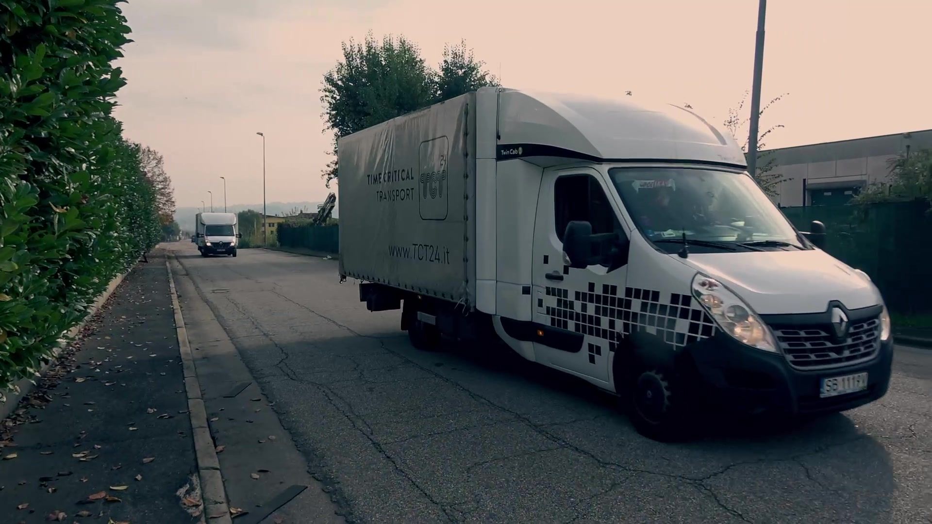 TCT24 curtainsider truck arriving on a tree-lined road
